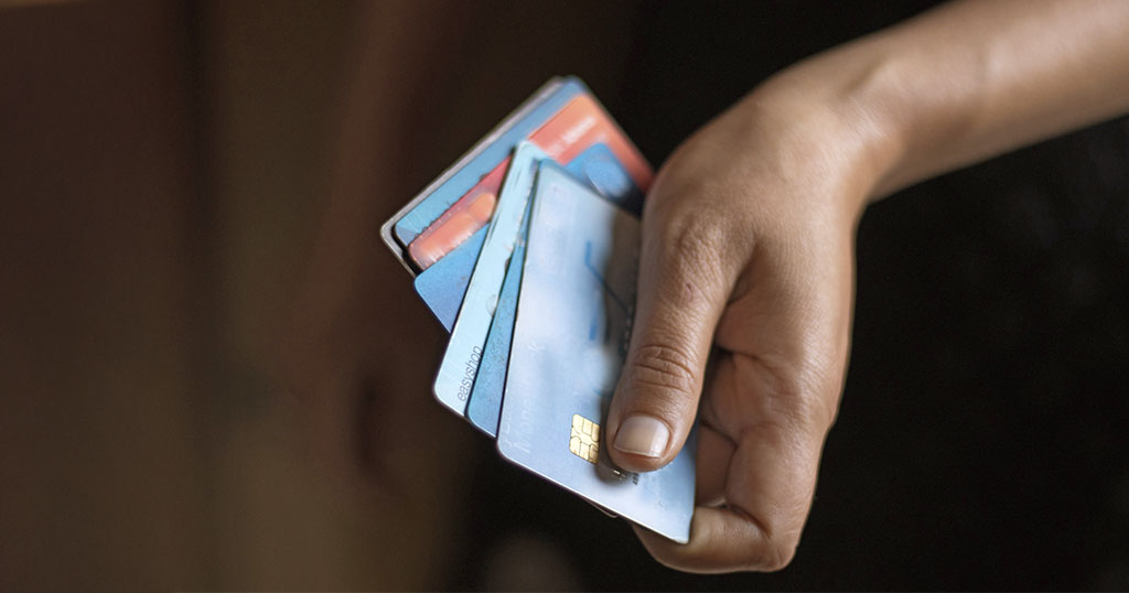 A person holding multiple credit cards in their hand