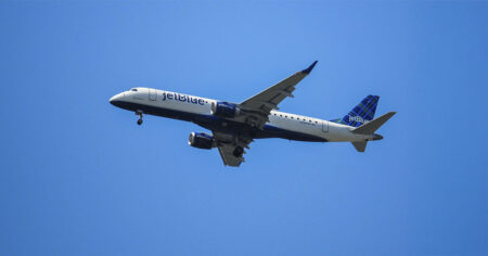 An airplane flying against a clear blue sky