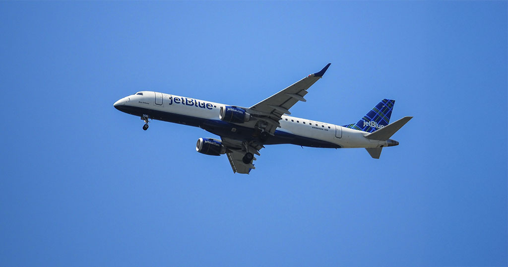 An airplane flying against a clear blue sky