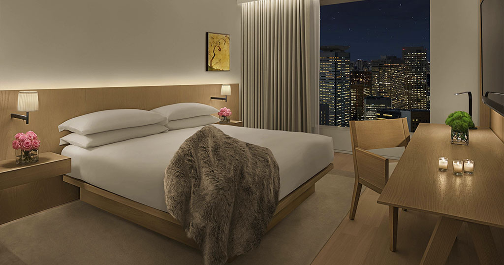 A cozy hotel room with a city view at night