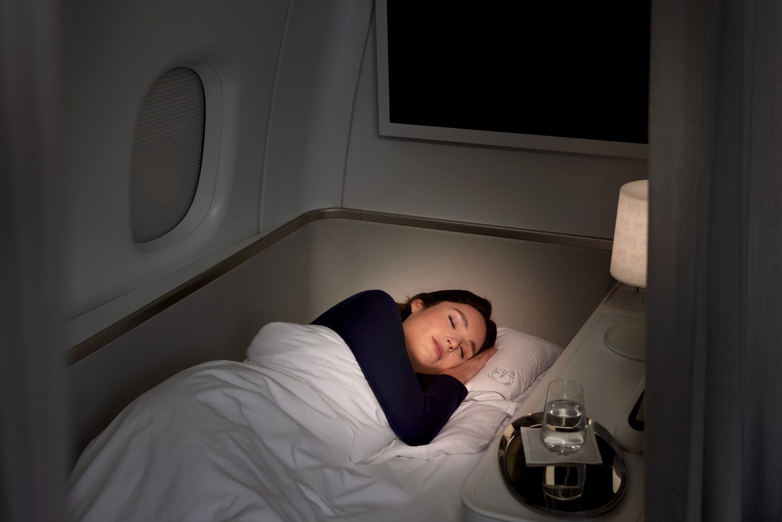 Passenger asleep in the two-meter bed of the Air France La Première suite